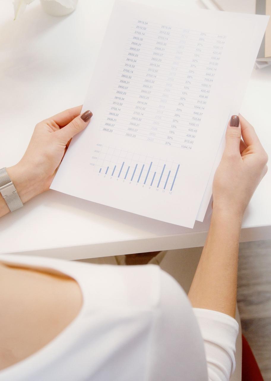 Empresária analisando relatório financeiro com gráficos e indicadores em mãos